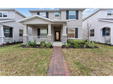 Two-story house with gray siding, brick accents, and a landscaped front yard at 11836 Language Way, Orlando, FL 32832