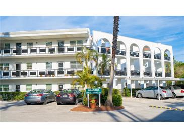 A bright, white condo building showcasing an interesting architectural design and carport parking at 100 El Camino Dr # 102, Winter Haven, FL 33884