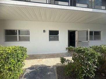 Exterior view of condo building with entrance and landscaping at 100 El Camino Dr # 102, Winter Haven, FL 33884