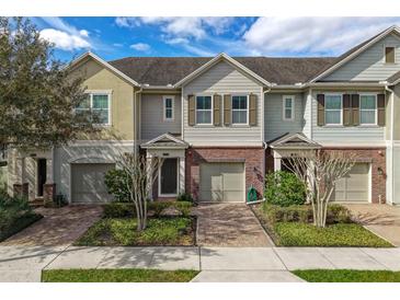 Three-story townhouses with attached garages and landscaped yards at 1076 Taramundi Dr, Oviedo, FL 32765