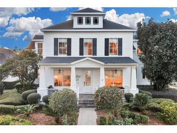 Two-story white house with black shutters, porch, and landscaped yard at 11401 Camden Park Dr, Windermere, FL 34786