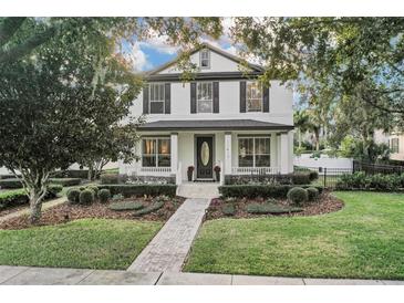 Charming two-story home with a well-manicured front yard, inviting curb appeal, and a cozy front porch with beautiful landscaping at 11413 Camden Park Dr, Windermere, FL 34786