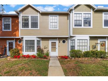 Tan and orange townhouses with landscaping and walkways at 11729 Whitewing Ct, Orlando, FL 32837