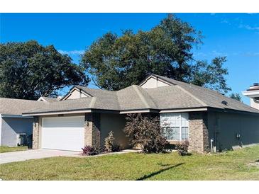 Brick house with white garage door and landscaped lawn at 1216 Windward Dr, Apopka, FL 32703