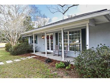 Charming single story home featuring a covered porch, white columns, and decorative front door wreaths at 1821 Stanley St, Longwood, FL 32750