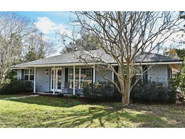 Ranch style home with grey siding, white trim, and rocking chairs on the porch at 1821 Stanley St, Longwood, FL 32750