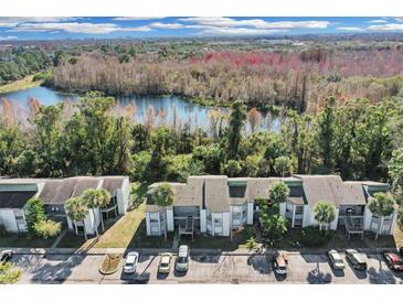 Aerial view of condo community near lake, showcasing building and parking at 2622 Lemon Tree Ln # K, Orlando, FL 32839