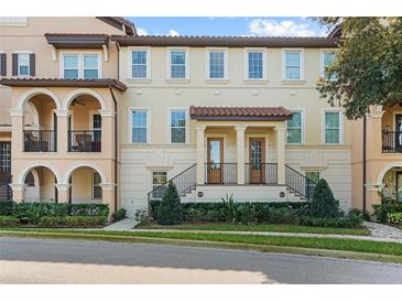 Elegant two-story townhouse featuring a tile roof and a beautifully landscaped entrance at 417 Pavia Loop, Lake Mary, FL 32746