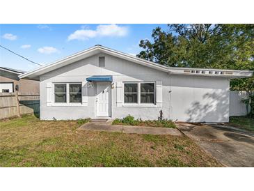 One-story house with white exterior, driveway, and small yard at 4401 Santee St, Orlando, FL 32804