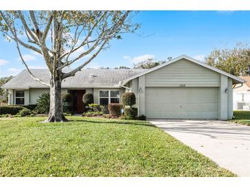 Single-story house with attached garage and well-maintained lawn at 4818 Breezy Palms Ct, Windermere, FL 34786