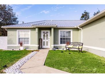 Green house with metal roof, walkway, and landscaped lawn at 652 Mountain Way Ave, Deltona, FL 32738