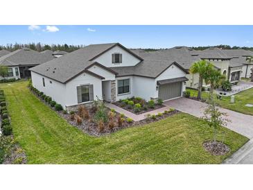 Two-story house with gray roof, landscaping, and brick driveway at 960 Ladera Ranch Rd, Kissimmee, FL 34759