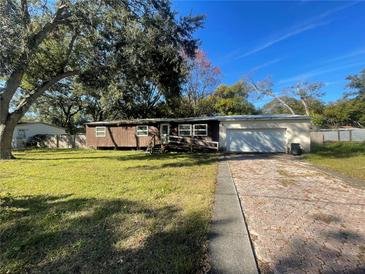 Ranch-style home with a carport and mature trees at 9732 8Th Ave, Orlando, FL 32824