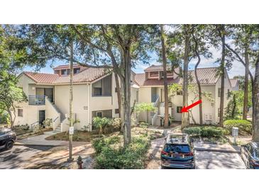 Inviting exterior of a two-story home with a tile roof and well-manicured landscaping, and blue stair rails at 1000 Winderley Pl # 143, Maitland, FL 32751