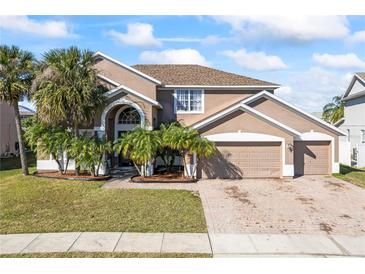 Two-story house with three-car garage and palm trees at 2606 Maggiore Cir, Kissimmee, FL 34746