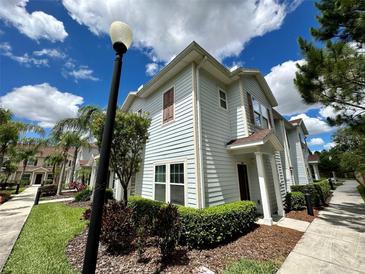 Two-story light blue townhome with landscaping and walkway at 3208 Oyster Ln, Kissimmee, FL 34747