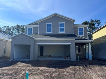 New two-story home with a large garage and gray siding awaits landscaping at 5238 Prairie Preserve Run, St Cloud, FL 34772
