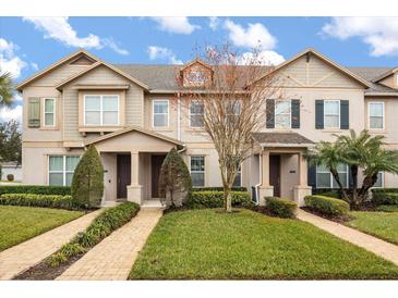 Tan two-story townhouses with dark brown doors, landscaping, and paved walkways at 7236 Shadeview Aly, Windermere, FL 34786