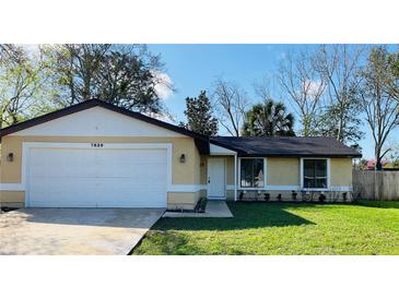 Charming one-story home featuring an attached two-car garage and a well-maintained front yard at 7839 Murcott Cir, Orlando, FL 32835
