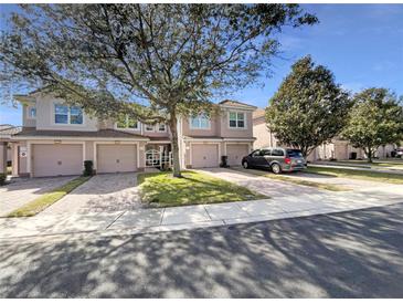Front view of townhouses with garages and landscaping at 1214 Romani Ave # 10240, Davenport, FL 33896