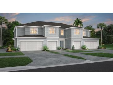 Two-story townhome with gray siding, three-car garage, and landscaping at 2575 Winsome Way, Davenport, FL 33896