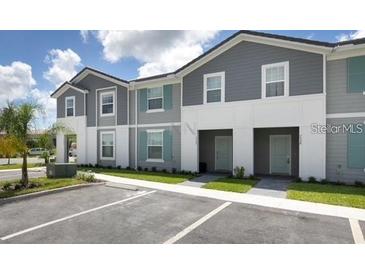 Two-story townhome with gray siding and teal accents at 7530 Oak Spring Ln, Davenport, FL 33837