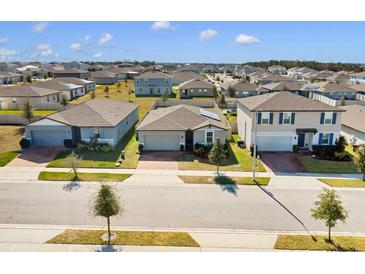 Aerial view of three houses in a new suburban neighborhood at 841 Teton St, Haines City, FL 33844