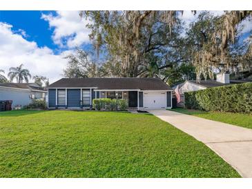 Charming single-story home featuring a well-manicured lawn, mature trees, and a welcoming facade at 1222 Golfview St, Orlando, FL 32804