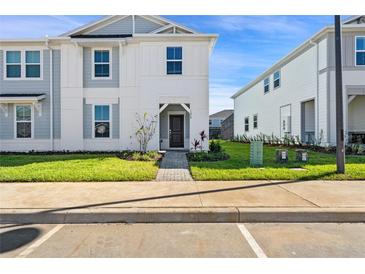 Two-story house with gray siding, landscaping, and a paved walkway at 1274 Shoreside St, Clermont, FL 34714