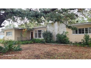 Ranch-style home with mature landscaping and brick facade at 1425 N Hiawassee Rd, Orlando, FL 32818