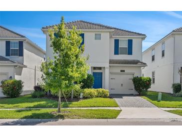 Two-story house with white exterior, blue shutters, and a landscaped lawn at 1551 Flange Dr, Davenport, FL 33896