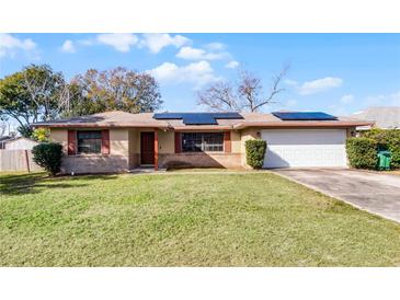 Single-story house with solar panels, attached garage, and well-maintained lawn at 1640 Templewood Ave, Deltona, FL 32725