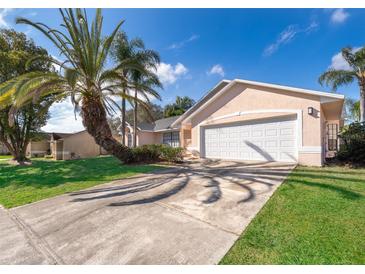 Tan house with white garage door and palm trees, in a residential neighborhood at 2006 Key Lime St, Ocoee, FL 34761