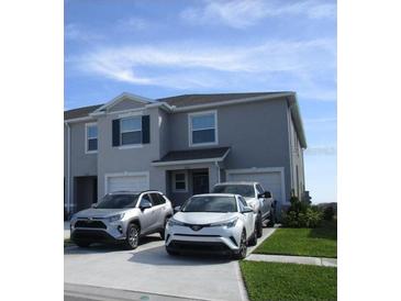 Two-story house with gray siding, two-car driveway, and landscaping at 2252 Tay Wes Dr, St Cloud, FL 34771