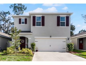 Two-story house with gray siding, brown shutters, and a two-car garage at 325 Pelham Park Dr, Deland, FL 32720