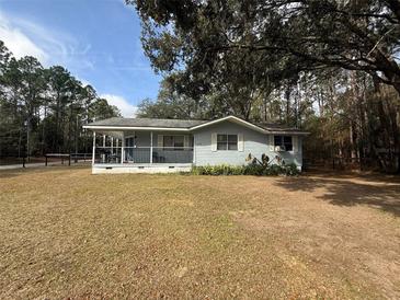 Ranch style home with covered porch, situated on a large lot with mature trees at 5690 Sw 202Nd Ct, Dunnellon, FL 34431