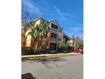 Three-story apartment building with yellow walls and palm trees at 6240 Contessa Dr # 101, Orlando, FL 32829