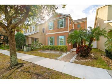 Two-story house with orange siding, landscaping, and a walkway at 6370 Golden Dewdrop Trl, Windermere, FL 34786