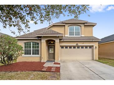 Charming two-story home featuring a manicured lawn, a two-car garage, and welcoming front entrance at 7525 Azalea Cove Cir, Orlando, FL 32807