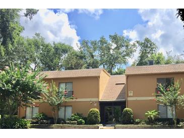 Tan building exterior with lush landscaping and a walkway at 90 Moree Loop # 16, Winter Springs, FL 32708