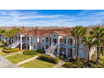 Two-story condo building with attractive landscaping and a tiled roof at 13917 Timberland Dr # 201, Orlando, FL 32824