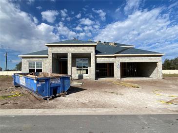 New home's exterior featuring block construction, spacious two-car garage, and a modern design under a partly cloudy sky at 2710 Ravencliffe Ter, Oviedo, FL 32765