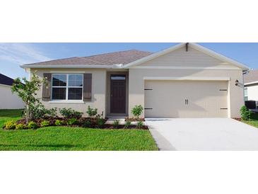 One-story home with light beige siding, brown door, and attached two-car garage at 2924 Moulin Rd, Davenport, FL 33837