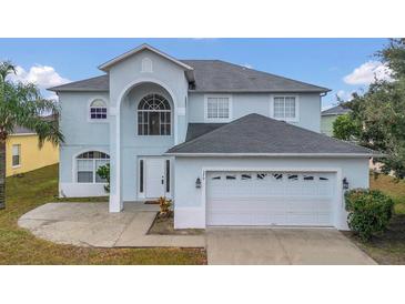 Two-story house with light blue exterior, white garage door, and landscaping at 370 Aldershot Ct, Kissimmee, FL 34758