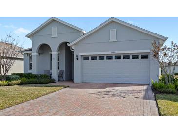 Gray house with a two-car garage and a brick paved driveway at 3999 Night Heron Dr, Sanford, FL 32773