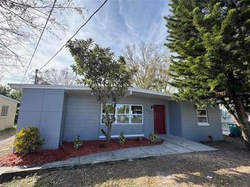 Newly renovated home with gray exterior, red door, and landscaping at 4072 Shellman St, Orlando, FL 32811