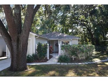 Front view of charming house with walkway and mature trees at 505 Harvard Pl, Apopka, FL 32703