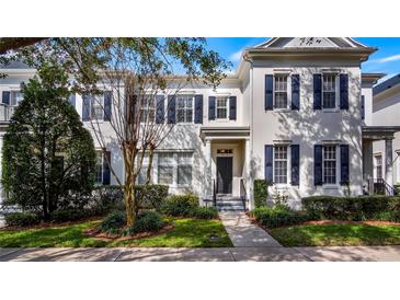 White two-story townhome with dark shutters and a manicured lawn at 5419 Baldwin Park St, Orlando, FL 32814