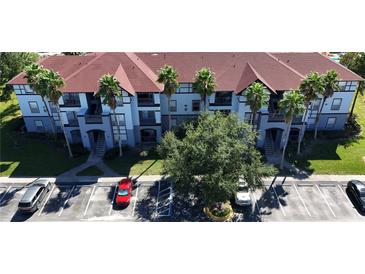 Apartment complex with red roofs, palm trees, and ample parking at 5538 Pga Nw Blvd # 5025, Orlando, FL 32839