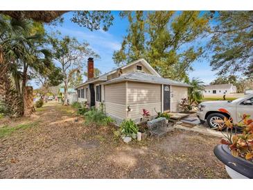 Tan house exterior with mature trees and a spacious yard at 590 W Vine St, Bartow, FL 33830